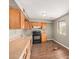 This cozy kitchen features wood cabinets, laminate countertops, black appliances, and a window with wrought iron at 6426 W Mulberry Dr, Phoenix, AZ 85033
