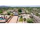 Aerial view of a home with a pool and grassy backyard in a desert neighborhood with mountain views at 7101 E Cholla St, Scottsdale, AZ 85254