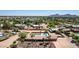 Aerial view of a home with a pool and grassy backyard in a desert neighborhood with mountain views at 7101 E Cholla St, Scottsdale, AZ 85254