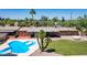 Inviting backyard with a unique pool, grassy area, patio with seating and fully enclosed for privacy at 7101 E Cholla St, Scottsdale, AZ 85254