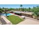 Aerial view of a backyard featuring a pool, grass area and a covered patio with stone walkways at 7101 E Cholla St, Scottsdale, AZ 85254