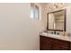Bathroom with a dark wood vanity, granite countertop, and decorative lighting above the framed mirror at 7101 E Cholla St, Scottsdale, AZ 85254