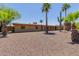 Tan single-story home with desert landscaping, including tall palm trees and a saguaro cactus at 7101 E Cholla St, Scottsdale, AZ 85254