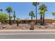 Desert home featuring a low-pitched roof, desert landscaping, and palm trees at 7101 E Cholla St, Scottsdale, AZ 85254