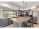 Well-lit kitchen boasts granite countertops, stainless appliances, blue pendant lighting, and backyard pool views at 7101 E Cholla St, Scottsdale, AZ 85254