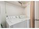 Laundry room with a standard white washer and dryer, shelf, and pale pink curtain at 7101 E Cholla St, Scottsdale, AZ 85254