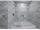 Close up of luxury tub shower encased in marble, with a large shower head in a bright modern bathroom at 7117 E Rancho Vista Dr # 6007, Scottsdale, AZ 85251