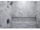 Close up of the marble tiled shower with rainfall shower head and built in bench and shelving at 7117 E Rancho Vista Dr # 6007, Scottsdale, AZ 85251