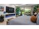 The main bedroom features a fireplace, TV, and access to the outdoor living space with lush plants at 7167 E Rancho Vista Dr # 3002, Scottsdale, AZ 85251