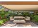 Covered patio with modern table, bench seating, and lush greenery for comfortable outdoor dining and relaxation at 7167 E Rancho Vista Dr # 3002, Scottsdale, AZ 85251