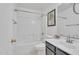 Well-lit bathroom with a shower-tub combo, toilet, and vanity with black cabinets at 7551 W Pasadena Ave, Glendale, AZ 85303