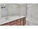 Bathroom featuring a double sink vanity, large mirror, and shower and tub combo at 7551 W Pasadena Ave, Glendale, AZ 85303
