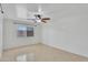 Bright bedroom featuring tile floors, a ceiling fan, and a large window providing lots of natural light at 7551 W Pasadena Ave, Glendale, AZ 85303