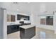 Bright kitchen with dark cabinetry, stainless appliances, an island with stone countertops, and a large window at 7551 W Pasadena Ave, Glendale, AZ 85303