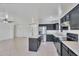 Open kitchen with dark cabinetry, stainless steel appliances, island with stone countertops, and ample lighting at 7551 W Pasadena Ave, Glendale, AZ 85303