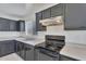 Cozy kitchen features dark cabinetry, a modern stove, and ample counter space with lots of natural light at 7551 W Pasadena Ave, Glendale, AZ 85303