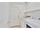 Convenient laundry room with white washer and dryer and open shelving at 7551 W Pasadena Ave, Glendale, AZ 85303