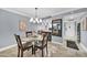 Bright dining area featuring a round glass table, chandelier, and adjacent bar area at 7625 E Camelback Rd # B138, Scottsdale, AZ 85251