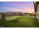 Sprawling backyard with a putting green, mature trees, and privacy fence at 10322 E Topaz Ave, Mesa, AZ 85212