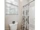 Bathroom with white toilet, shower with patterned curtain and a window at 10322 E Topaz Ave, Mesa, AZ 85212