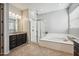 Bright bathroom featuring a glass shower, soaking tub, granite counters and tile floor at 10322 E Topaz Ave, Mesa, AZ 85212