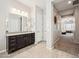 Bathroom featuring dark cabinets, granite counters, double sinks and tile flooring at 10322 E Topaz Ave, Mesa, AZ 85212