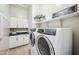 Well-organized laundry room with modern appliances, countertops and upper cabinets at 10322 E Topaz Ave, Mesa, AZ 85212