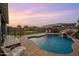 Beautiful backyard with a private pool featuring a rock waterfall and mature landscaping at 10322 E Topaz Ave, Mesa, AZ 85212