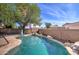 Lush backyard features a pool with a rock waterfall, creating a serene outdoor oasis at 10402 E Javelina Ave, Mesa, AZ 85209