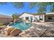 Resort-style backyard pool with rock features, complemented by a well-maintained landscape at 10402 E Javelina Ave, Mesa, AZ 85209