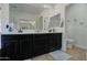 Double sink bathroom vanity featuring a spacious countertop, cabinet storage, with dual mirrors and vanity lighting at 10402 E Javelina Ave, Mesa, AZ 85209