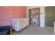 This bedroom features pink walls, carpet flooring and a white crib with a pink closet at 10402 E Javelina Ave, Mesa, AZ 85209