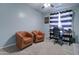 This bedroom features neutral walls, carpet flooring, and two brown leather armchairs at 10402 E Javelina Ave, Mesa, AZ 85209