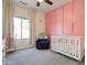 This bedroom features pink walls, carpet flooring and a white crib at 10402 E Javelina Ave, Mesa, AZ 85209