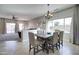 Bright dining room featuring an elegant chandelier, large windows, and stylish furniture at 10402 E Javelina Ave, Mesa, AZ 85209