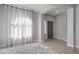 Bright living room featuring tile floors, a rug, neutral paint, and an adjacent hallway at 10402 E Javelina Ave, Mesa, AZ 85209