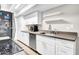 Modern kitchen with white cabinets, stainless steel dishwasher, floating shelves, and stone countertops at 10424 N 7Th Pl # 2, Phoenix, AZ 85020