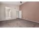 Bright bedroom featuring plush carpeting, neutral walls, and an ensuite bathroom entrance at 10923 W Ivory Ln, Avondale, AZ 85392