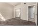Bedroom featuring neutral walls, carpet flooring, mirrored closet doors, and a door to the ensuite bathroom at 10923 W Ivory Ln, Avondale, AZ 85392