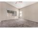 Bright bedroom featuring a ceiling fan, and carpet flooring, with windows for natural light at 10923 W Ivory Ln, Avondale, AZ 85392