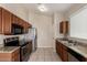 Traditional kitchen featuring tile floors, wood cabinetry, granite countertops, and stainless steel appliances at 10923 W Ivory Ln, Avondale, AZ 85392