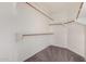 Empty walk-in closet with brown carpeting and multiple racks at 10923 W Ivory Ln, Avondale, AZ 85392