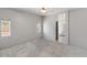 Bright bedroom with neutral carpet, ceiling fan, and natural light, complemented by an ensuite bathroom for added convenience at 13796 W Mauna Loa Ln, Surprise, AZ 85379