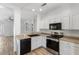 Well-lit kitchen featuring white cabinetry and modern appliances, flowing into living area at 13796 W Mauna Loa Ln, Surprise, AZ 85379