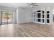 Spacious living room with wood-look floors, recessed lighting, and stylish built-in shelving at 13796 W Mauna Loa Ln, Surprise, AZ 85379