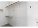 A walk-in closet with white walls and shelves for plenty of storage space at 13796 W Mauna Loa Ln, Surprise, AZ 85379