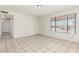 Spacious room with tile floors, white walls, a door and a window, offering a bright and airy space at 1512 W Crescent Ave, Mesa, AZ 85202