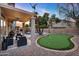 Inviting backyard featuring a putting green, seating area, pool, and an outdoor kitchen with string lights at 1574 E Scott Ave, Gilbert, AZ 85234