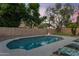 Backyard pool with a putting green, mature trees, and decorative string lights on the fence at 1574 E Scott Ave, Gilbert, AZ 85234