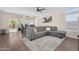 Living room with a gray sectional couch, ceiling fan, and sliding glass door leading to backyard at 1574 E Scott Ave, Gilbert, AZ 85234